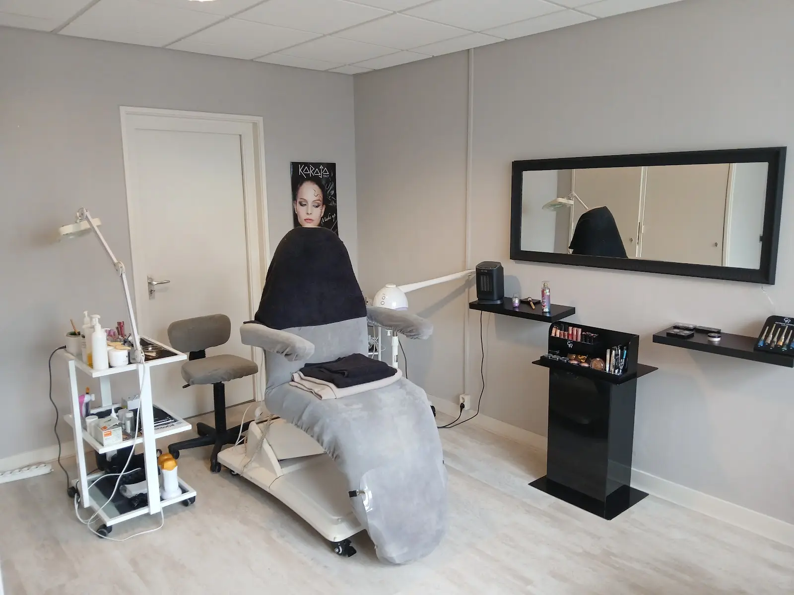 De behandelruimte van Beautysalon Jolanda: behandelstoel, lamp en spiegel